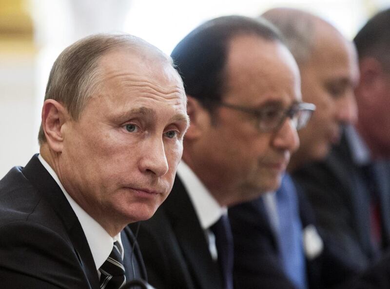 Russian president Vladimir Putin, left, and French president Francois Hollande, centre, attend a meeting with German chancellor Angela Merkel and Ukrainian president Petro Poroshenko at the Elysee Palace in Paris on October 2, 2015. Etienne Laurent/Pool Photo Via AP