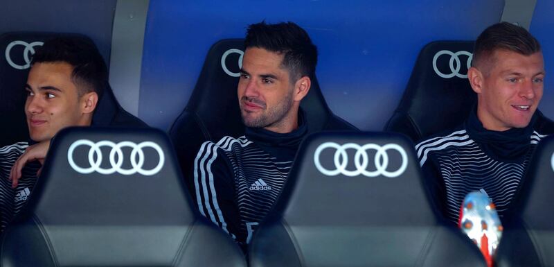 Real Madrid's players Sergio Reguilon, left, Isco, centre, and Toni Kroos sit on the bench. EPA