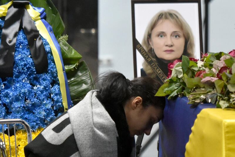 A relative attends a tribute ceremony and reacts in front of the flag-draped coffins of the 11 Ukrainians who died in a plane mistakenly shot down by Iran during a spike in tensions with Washington, which arrived in Boryapil airport, outside Kiev, on January 19, 2020. - Ukarine's President, Prime Minister and other officials attend the solemn ceremony at Kiev's Boryspil airport to see caskets with the remains of the downed plane's nine Ukrainian flight crew and two passengers being removed from the aircraft. (Photo by Sergei SUPINSKY / AFP)