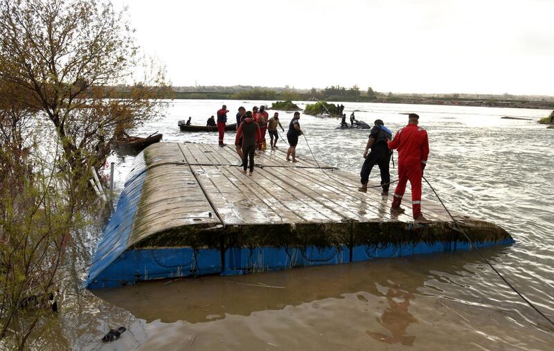 Members of Iraqi's civil defence units examine a sunken ferry in the Tigris river near Mosul. EPA