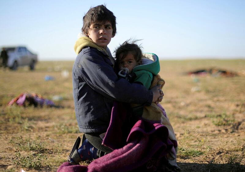 A boy holds a baby near the village of Baghouz, Deir Al Zor province, Syria March 1, 2019. REUTERS/Rodi Said     TPX IMAGES OF THE DAY