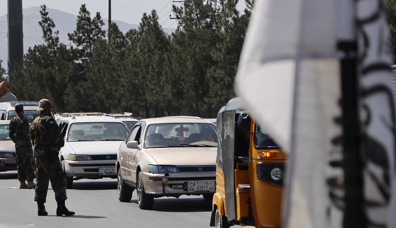 Taliban militants stop traffic at a roadside checkpoint in Kabul. EPA