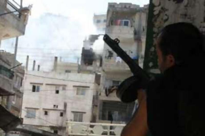 Smoke billows from the Jabal Mohsen neighbourhood while a Sunni Muslim gunman takes cover behind a wall in the Bab al-Tebbaneh district during clashes in between opponent factions the northern Lebanese city of Tripoli.