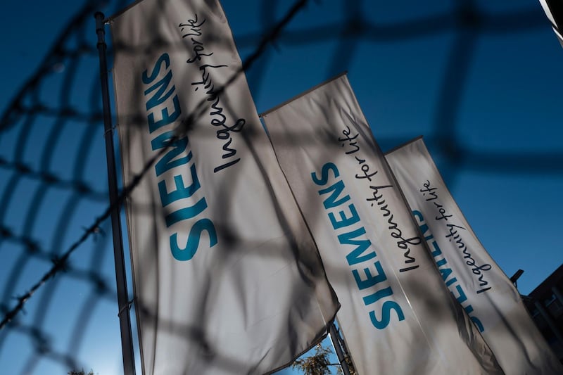 epa07133070 Flags with  the name logo and slogan of German industrial manufacturing company Siemens AG are seen in the locality of Siemensstadt in Berlin, Germany, 31 October 2018. Siemens CEO Joe Kaeser and Berlin Governing Mayor Michael Mueller sign an agreement for a new innovation campus in Berlin.  EPA/KAMIL ZIHNIOGLU