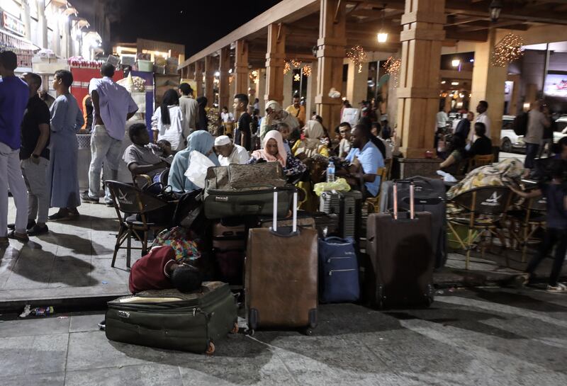 Passengers fleeing from Sudan wait outside  the railway station in Aswan, Egypt. EPA 