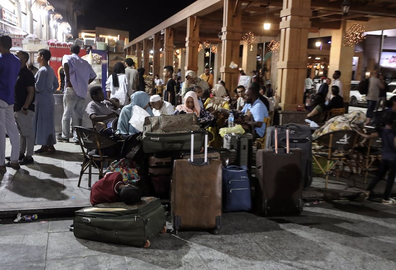 Passengers fleeing from Sudan wait outside  the railway station in Aswan, Egypt. EPA 