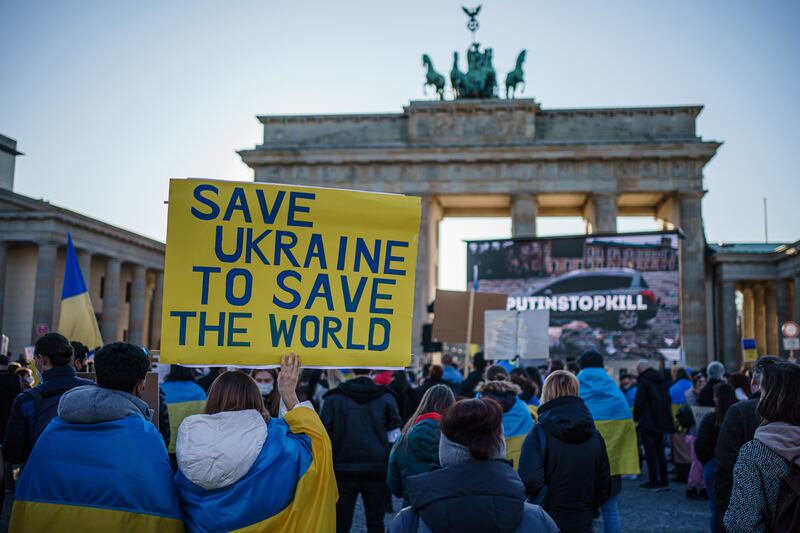 Protesters hold a placard reading 'Save Ukraine to save the world' during a demonstration in support of Ukraine in front of the Brandenburg Gate in Berlin. EPA