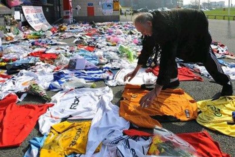 A well-wisher lays down a shirt with a message to ill Bolton Wanderers' player Fabrice Muamba at the Reebok Stadium in Bolton. Andrew Yates / AFP