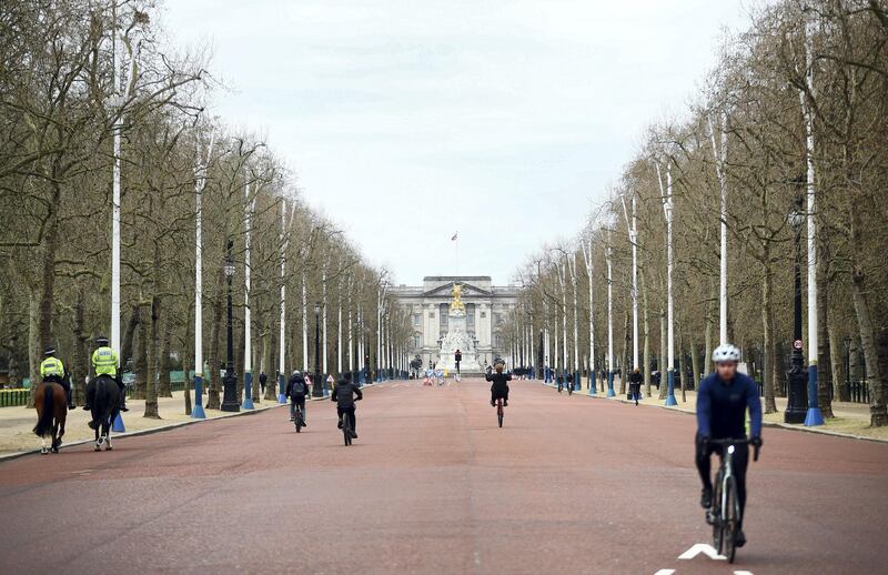 Cyclists ride along The Mall in front of Buckingham Palace in London, Britain, April 2, 2021. REUTERS/Hannah McKay