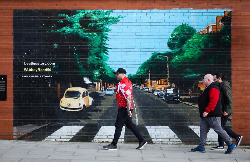 Liverpool fans walk past a mural of Beatles album cover Abbey Road at the Camp and Furnace in the city, before their team beat Chelsea in the Carabao Cup final at Wembley. EPA