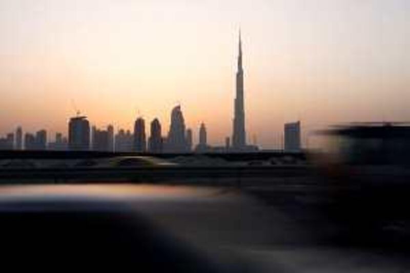 Dubai - October 10, 2009 - Cars speed by during dusk on highway 66 with the Burj Dubai and the Dubai skyline in the background October 10,2009. (Photo by Jeff Topping/The National) *** Local Caption ***  JT001-1010-BURJ DUBAI STOCK_MG_7644.jpg
