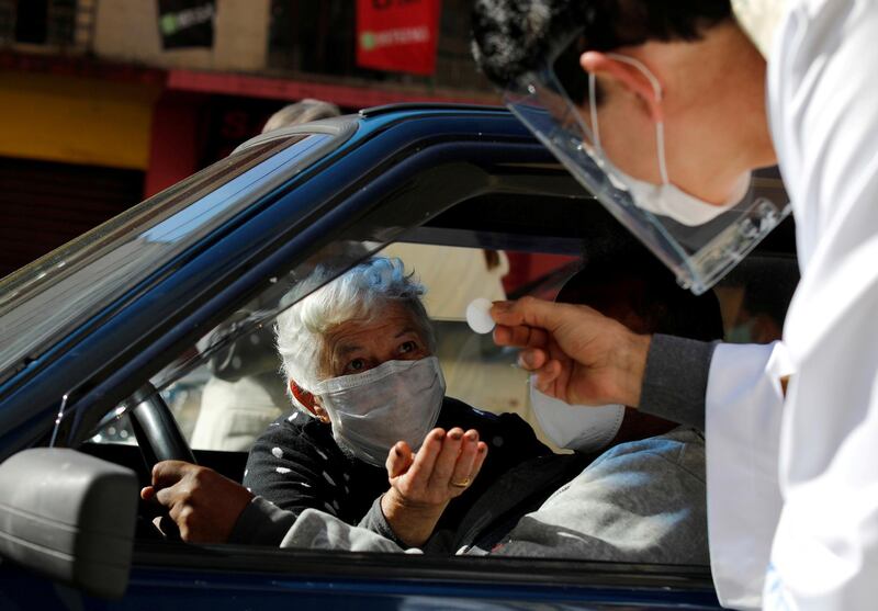 Catholic priest Reginaldo Manzotti gives Holy Communion to a woman at a drive-thru system on Mother's Day, as the spread of the coronavirus disease (COVID-19) continues in Curitiba, Brazil. REUTERS