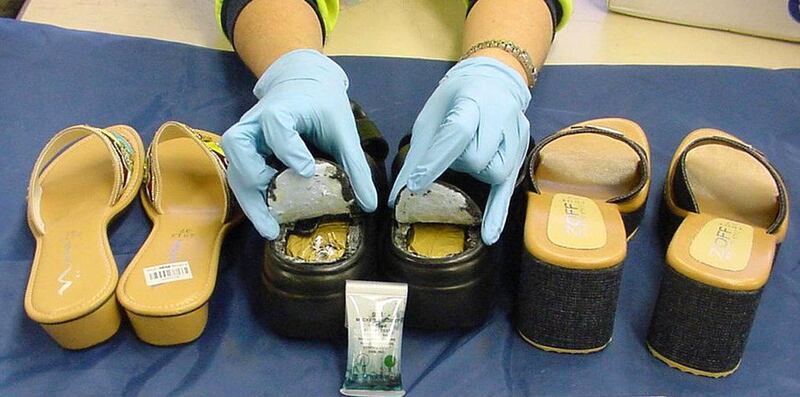 This Australian Customs Service handout photo released, 07 September 2004, in Sydney shows shoes seized by customs in which nearly half a kilo (1.1 lb) of heroin was found in the soles of a footwear consignment sent via post from Thailand. The shoes were seized 01 September only days after officers found heroin in another package concealed in six dinner plates posted from Cambodia, and in a third case before five Singaporeans were arrested upon arrival in Melbourne 06 September -- found with 4 kilos (9 lbs) of heroin inside the shoes on their feet.   AFP PHOTO/AUSTRALIAN CUSTOMS SERVICE/HO (Photo by AFP / AUSTRALIAN CUSTOMS SERVICE / AFP)