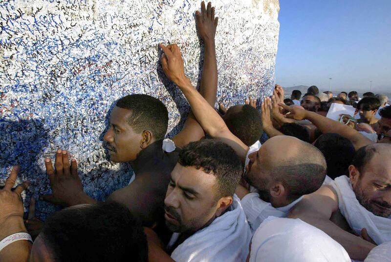 Pilgrims performing Hajj in January 2004 touch the monument at the summit of Jabal Arafat, where the Prophet Mohammed gave his last sermon.