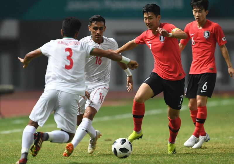 South Korea's captain Son Heung Min (2R) controls the ball past Iran's Amir Roustaei (2L) and Mohammad Zanjanab Moslemipour (L) during the men's football round of 16 match between Iran and South Korea at the 2018 Asian Games in Cikarang on August 23, 2018. (Photo by AAMIR QURESHI / AFP)