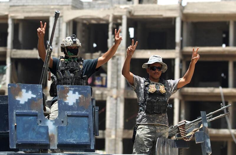 Iraqi government forces flash victory signs after gains against ISIL in Fallujah on June 10, 2016, as the extremists lost a vital supply line in neighbouring Syria. Ahmad Al Rubaye / AFP