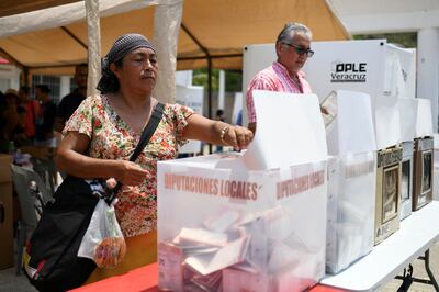 A woman casts her ballot in Mandinga, Mexico. Election authorities estimate turnout to be 60 per cent. Reuters