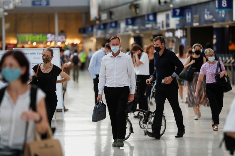 Commuters walk through Waterloo station during the morning rush hour. British Prime Minister Boris Johnson has called for caution as restrictions are lifted in England.