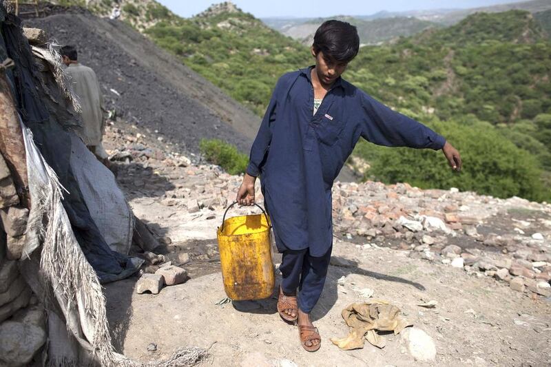 Samiullah, who says he is 14 years old, carries water for his uncle’s bath at a coal field in Choa Saidan Shah, Punjab. Although Pakistan has introduced legislation to deal with child labour, the problem is deeply entrenched in society. Sara Farid / Reuters