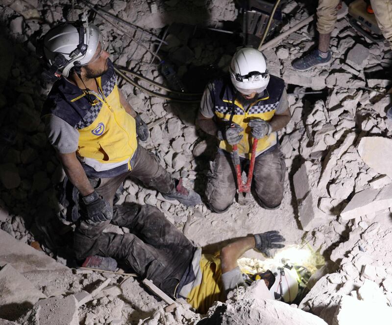 Rescue workers known as White Helmets break concrete during a search for survivors following Syrian government forces air strikes in the rebel town of Orum al-Kubra, in the northern province of Aleppo, late on August 10, 2018. - Heavy bombardment killed nearly 30 civilians across northern Syria yesterday, a monitor said, in some of the fiercest shelling of rebel-held areas there in months. (Photo by OMAR HAJ KADOUR / AFP)