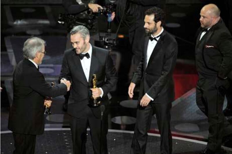 Steven Spielberg, left to right, gives Iain Canning, Emile Sherman and Gareth Unwin their Oscars for best motion picture for "The KingÕs Speech" at the 83rd Academy Awards on Sunday, Feb. 27, 2011, in the Hollywood section of Los Angeles. (AP Photo/Mark J. Terrill)