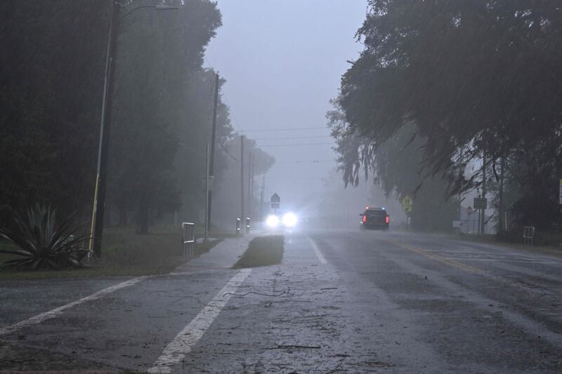 A police car drives through heavy rains in Archer, Florida. AFP