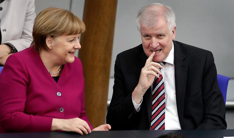 FILE - In this Wednesday, March 21, 2018 file photo, German Chancellor Angela Merkel, left, and German Interior Minister Horst Seehofer, right, talk during a meeting of the German federal parliament, Bundestag, in Berlin, Germany. (AP Photo/Michael Sohn, file)