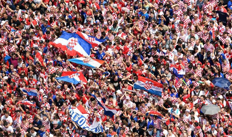 People wave flags as they gather for a "heroes' welcome" in tribute to the Croatian national football team. Denis Lovrovic / AFP