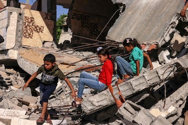 Palestinian children play amid the ruins of a building destroyed in Rafah, in the southern Gaza Strip. AFP