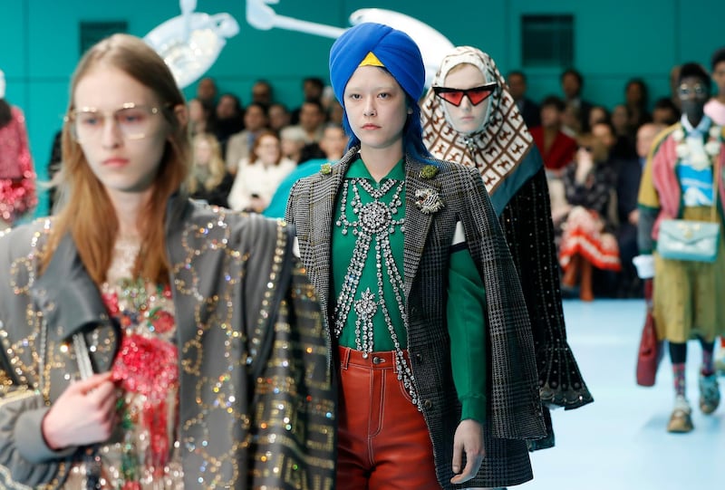 FILE - In this Feb. 21, 2018 file photo, models display items from Gucci's women's Fall/Winter 2018-2019 collection, presented during the Milan Fashion Week, in Milan, Italy. The top civil rights organization for Sikhs in the United States says Nordstrom has apologized to the community for selling an $800 turban they found offensive, but they are still waiting to hear from the Gucci brand that designed it, Saturday, May 18, 2019. (AP Photo/Antonio Calanni, File)