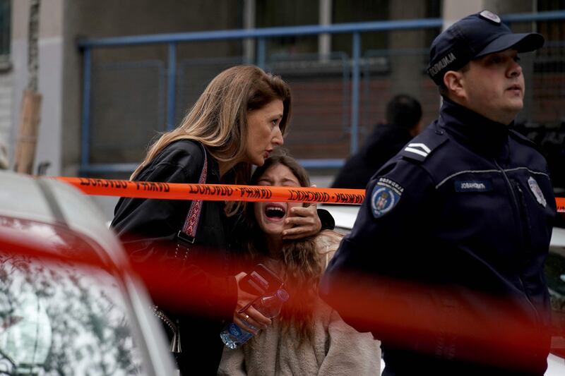 A woman embraces a child following a shooting at a school in Belgrade, Serbia. AFP