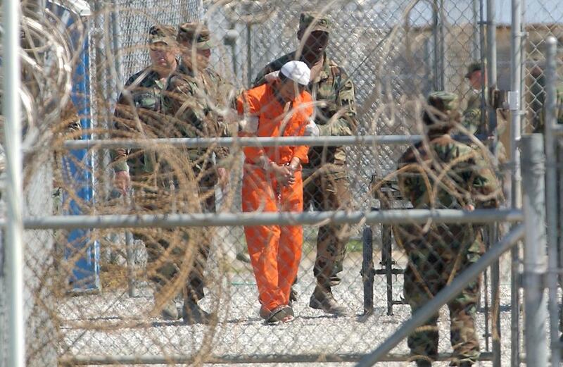 A detainee from Afghanistan is led by military police at Camp X-Ray in Guantanamo Bay, Cuba. Even if the prison is closed, writes Faisal Al Yafai, the repercussions for the rule of law will continue long after. (AP Photo/Lynne Sladky, File)