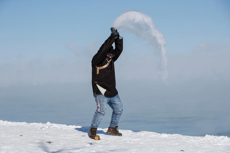 A man tosses hot water into the freezing cold air by Lake Michigan in Chicago. EPA