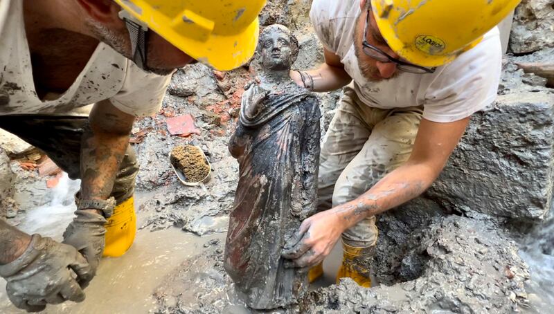 A handout photo made available by the University for Foreigners of Siena (Universita per Stranieri di Siena) shows a statue (a young toga) being recovered from the mud during the discovery of a votive deposit in the excavations of San Casciano dei Bagni, Tuscany, Italy, 07 November 2022 (issued 08 November 2022).  Protected for 2,300 years from the mud and boiling water of the sacred basins, a never-before-seen votive deposit has re-emerged from the excavations of San Casciano dei Bagni, in Tuscany, with over 24 bronze statues of refined workmanship, five of which almost one meter high, all intact and in good condition.   EPA / JACOPO TABOLLI  /  Universita per Stranieri di Siena  /  HANDOUT  HANDOUT EDITORIAL USE ONLY / NO SALES