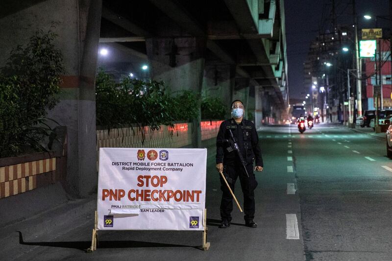 An armed police officer stands by a checkpoint placed to implement a curfew in the country's capital amid rising coronavirus  cases. REUTERS/Eloisa Lopez