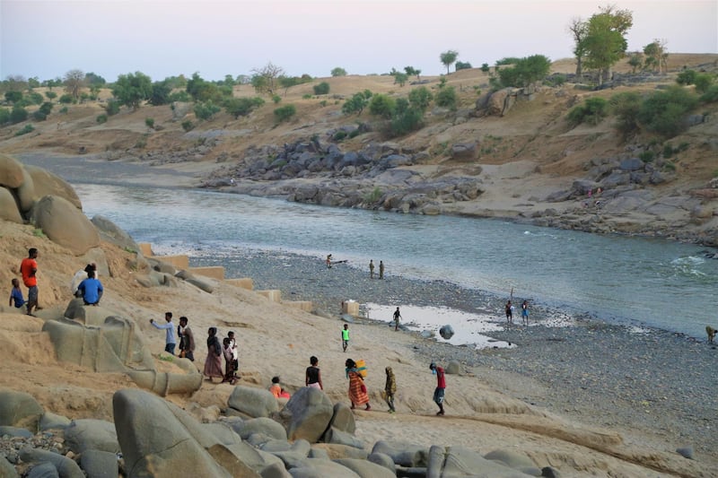 Ethiopians who fled the ongoing fighting in Tigray region, collect water from the Setit river on the Sudan-Ethiopia border in eastern Kassala state. World Food Program, HO via REUTERS