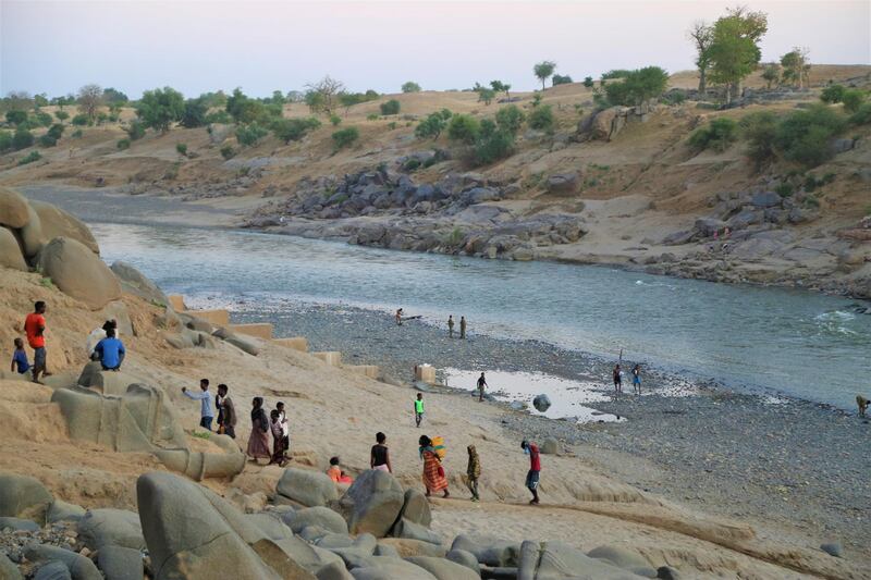 Ethiopians who fled the ongoing fighting in Tigray region, collect water from the Setit river on the Sudan-Ethiopia border in eastern Kassala state.