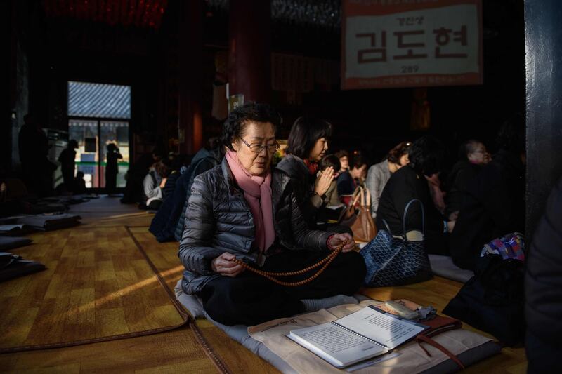 Parents and relatives of students sitting the annual college entrance exams offer prayers at a Buddhist temple in Seoul, South Korea. AFP