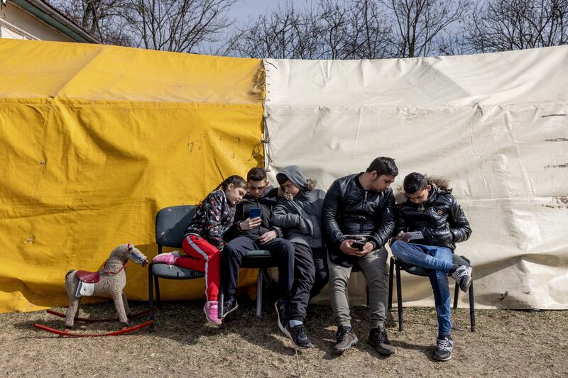 A refugee family sit in front of a tent at a temporary shelter offered by the Free Christian Church in Uszka, Hungary.  Getty Images