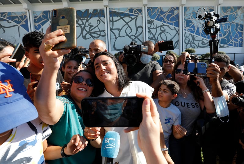 Jabeur poses for a photo with fans outside Carthage International Airport in Tunis. Reuters