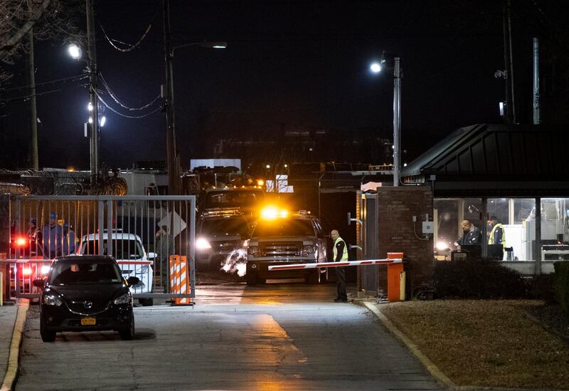 People stand at the gate of a Con Edison facility in the Queens borough of New York where an earlier transformer explosion lit up the night sky for several minutes. AP Photo