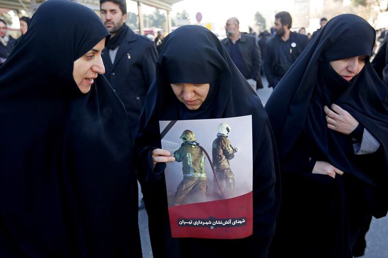 Iranian women mourn during the funeral procession for firemen killed when the city’s oldest high-rise collapsed after a blaze, in Tehran on January 30, 2017. Tens of thousands of Iranians poured on to the streets of the Iranian capital for the funeral of firefighters killed when the 15-storey Plasco building, home to a shopping centre and hundreds of clothing suppliers, collapsed two weeks ago while emergency services were still evacuating people from a huge fire. Atta Kenare / AFP