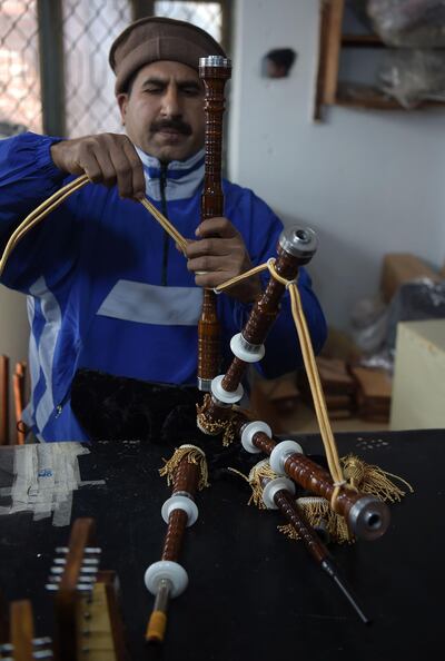 In this picture taken on January 25, 2019, a Pakistani worker fixes a component to make a set of bagpipes at the Mid East bagpipe factory in the eastern city of Sialkot. Umer Farooq's grandfather and father made bagpipes. Now he is the third generation to take up the tradition in Pakistan, which is thousands of kilometres from Scotland yet sells thousands of bagpipes each year. 
 - TO GO WITH: Pakistan-music-bagpipes, FEATURE by Joris FIORITI
 / AFP / AAMIR QURESHI / TO GO WITH: Pakistan-music-bagpipes, FEATURE by Joris FIORITI
