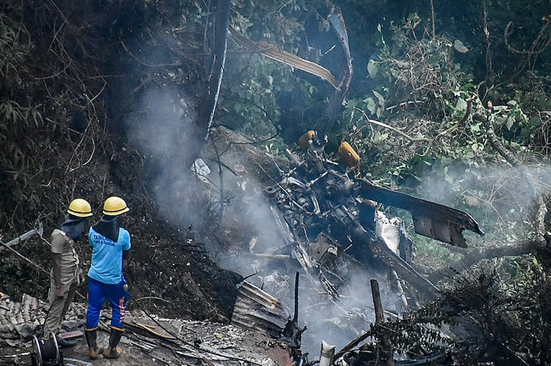 Firemen and rescue workers view the debris of the IAF Mi-17V5 helicopter crash site near Coonoor, in Tamil Nadu.  AFP