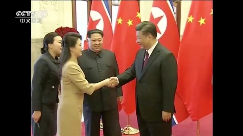 North Korean leader Kim Jong Un watches as his wife Ri Sol Ju shakes hands with Chinese President Xi Jinping, in this still image taken from video released on March 28, 2018. CCTV via Reuters