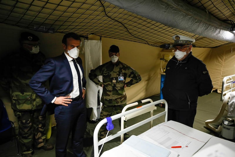 TOPSHOT - French President Emmanuel Macron (L) wears a face mask during the visit of the military field hospital outside the Emile Muller Hospital in Mulhouse, eastern France, on March 25, 2020, on the ninth day of a lockdown aimed at curbing the spread of the COVID-19 (novel coronavirus) in France.  / AFP / POOL / Mathieu CUGNOT
