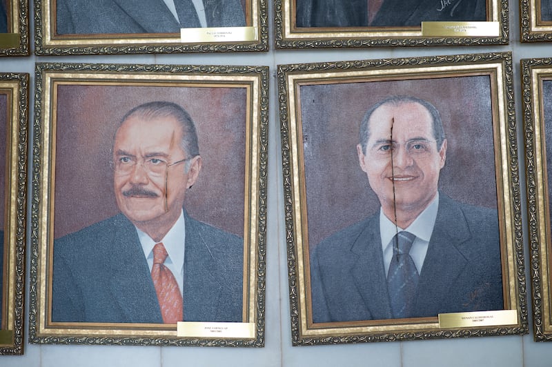 Damaged portraits hang in the Brazilian National Congress after the riot, in which more than 1,200 people were detained. Getty