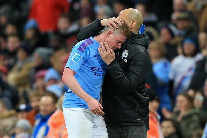 Manchester City manager Pep Guardiola embraces midfielder Kevin De Bruyne as he leaves the pitch. AFP