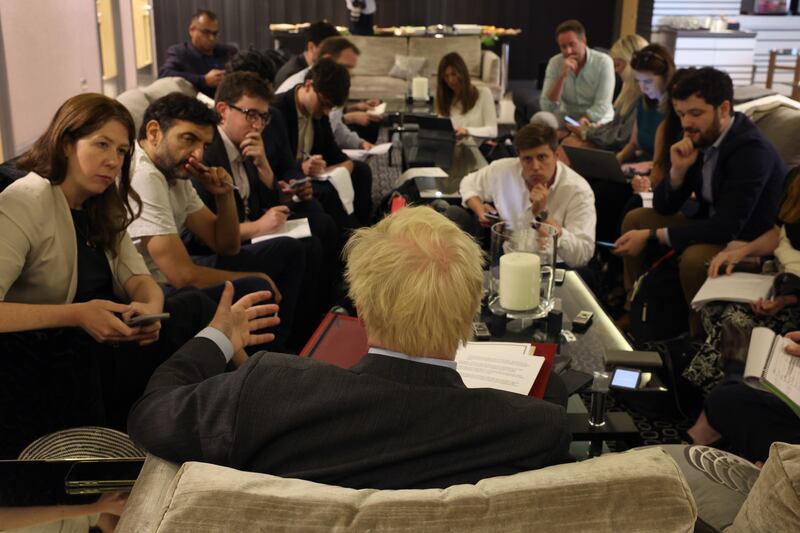 British Prime Minister Boris Johnson confers with advisers before departing from London Stansted Airport on Wednesday, to attend the Commonwealth Heads of Government Meeting in Rwanda. Getty Images