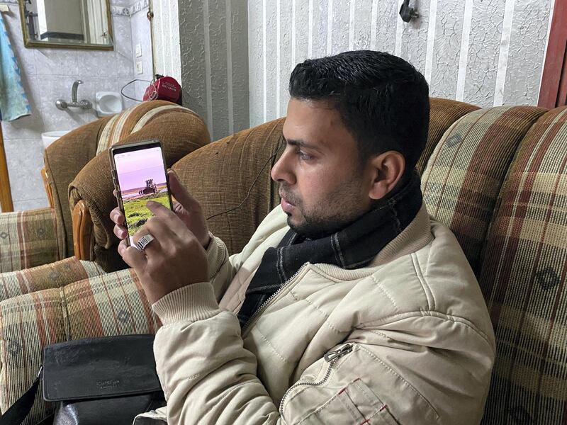 Muthana Al-Najjar with the phone he used to record the video of Israel bulldozer